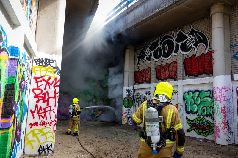 Rookontwikkeling over treinspoor door brandende scooter Rotterdam